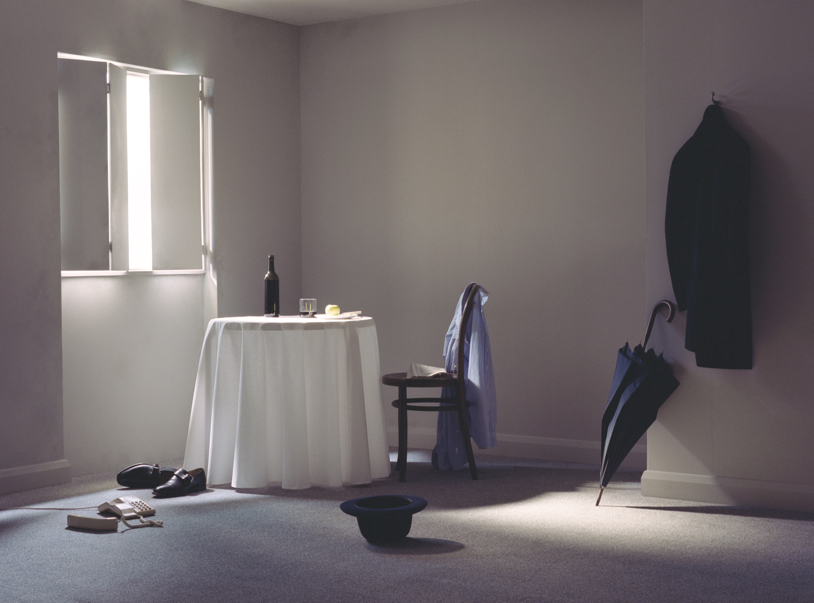 Photograph by Adam Barclay featuring a staged composition of various objects, including an umbrella, a bowler hat, a telephone, and some mens' shoes.