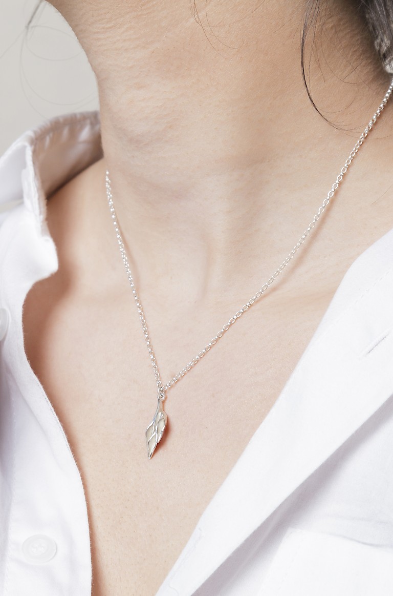 Delicate silver necklace by Daisy Lee Jewels, pendant in the shape of a small floret of petals or leaves.