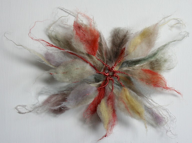 Textile work by Lyn Carruthers, a flower-like form made from felting red, yellow and purple wool.