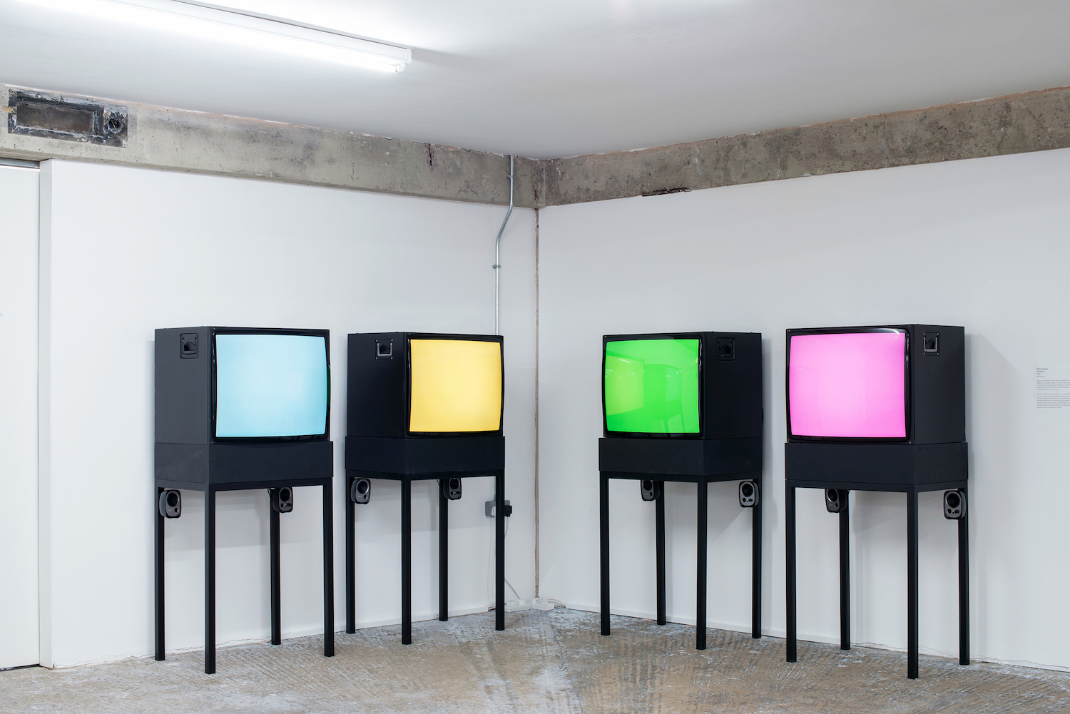 Installation by Vicky Hayward, four CRT monitors arranged in pairs each display a solid colour: blue, yellow, green, and pink.